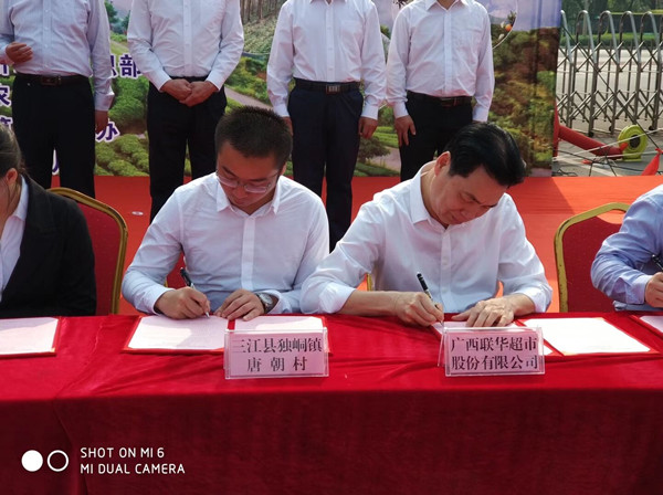 唐朝村第一书记杨小浒（左）与广西联华签订300万元的农产品销售合同.jpg